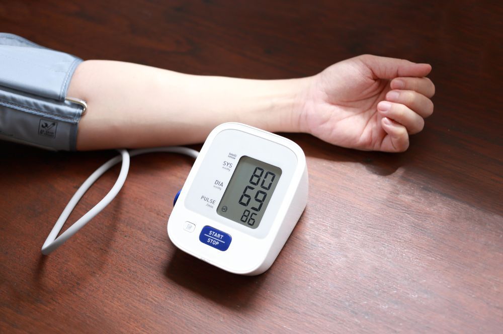 Pohľad na ruku s napojeným tlakomerom, ktorý ukazuje nízky krvný tlak označovaný aj hypotenzia , ktorý je sprevádzaný viacerými negatívnymi príznakmi. 