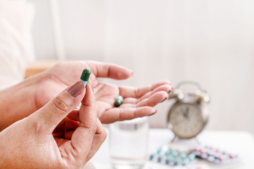 Pohľad na ruky, ktoré držia tabletku – antibiotiká, ktoré sú potrebné na liečbu šarlachu, keďže ide o bakteriálnu infekciu. 